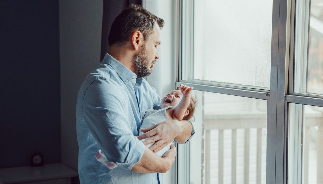 Vater, hält schreiendes Baby auf dem Arm.