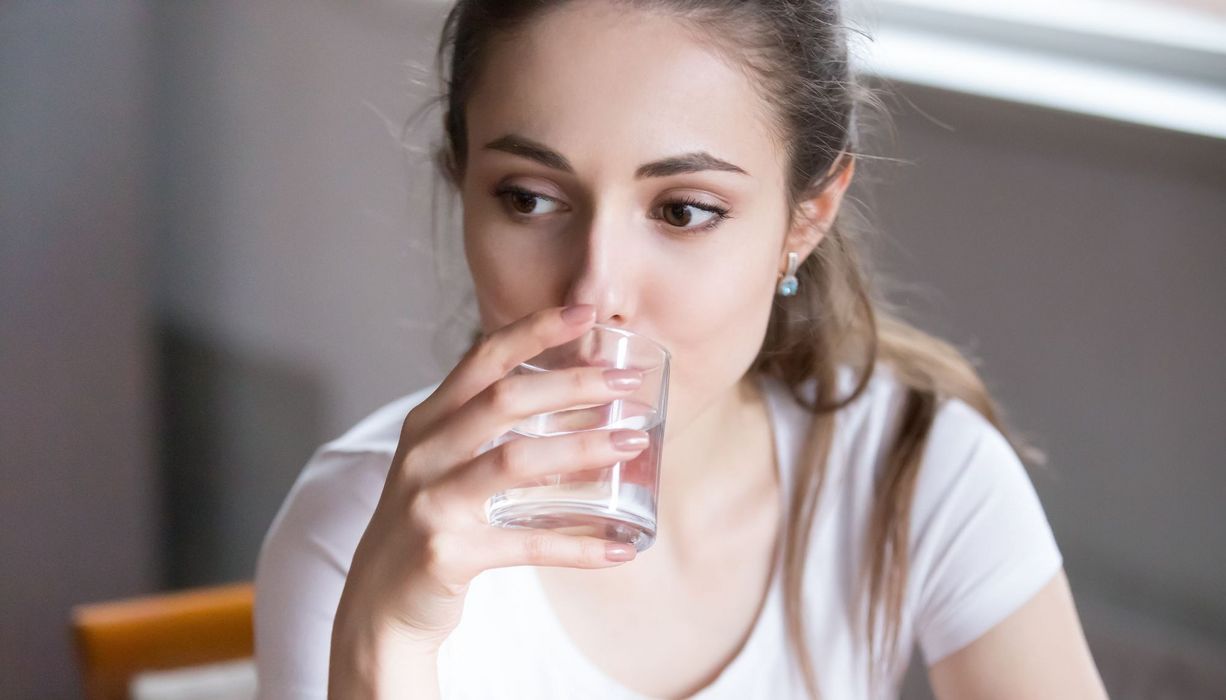 Junge Frau, trinkt Wasser.