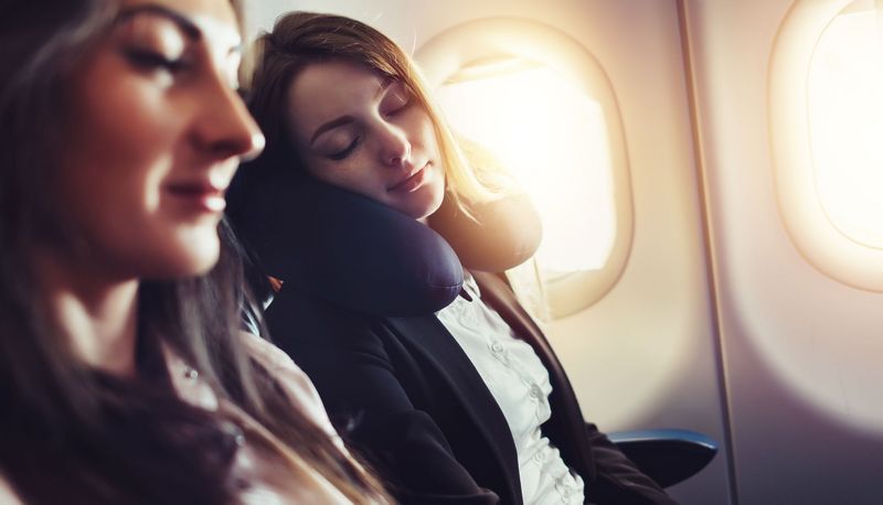 Zwei junge Frauen im Flugzeug, schlafen.