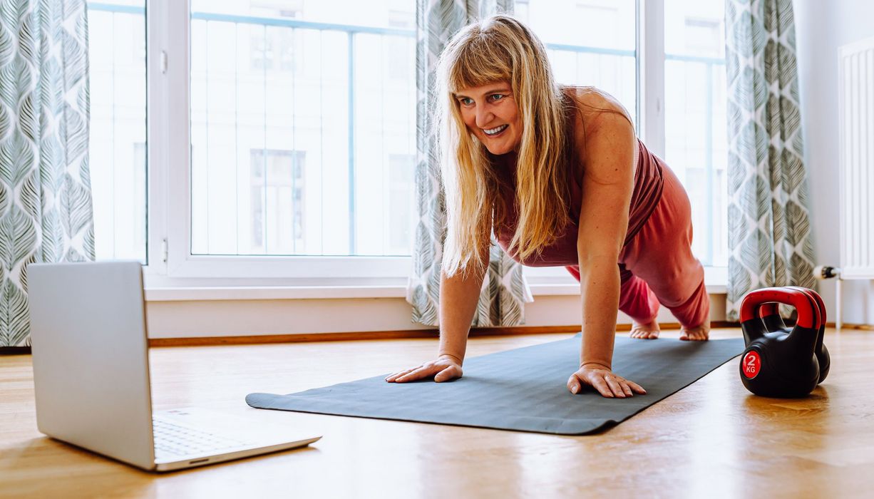 Übergewichtige Frau, macht Sport mit dem Laptop.