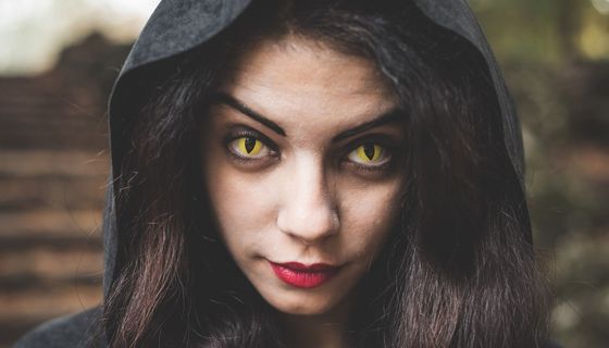 Frau mit gelben Kontaktlinsen, die ihre Augen geschlitzt aussehen lassen.