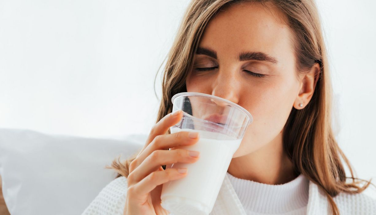 Frau, trinkt ein Glas Milch.