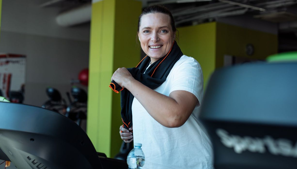 Frau mit leichtem Übergewicht, joggt auf einem Laufband.