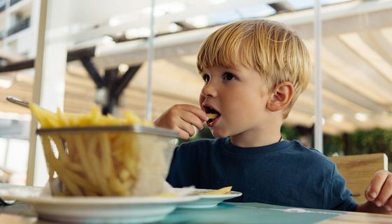 Ein Dreijähriger isst Pommes.