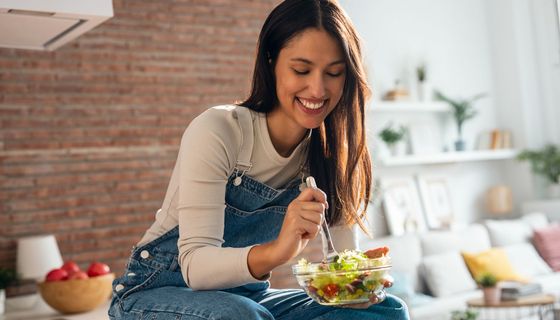 Frau, isst einen Salat.