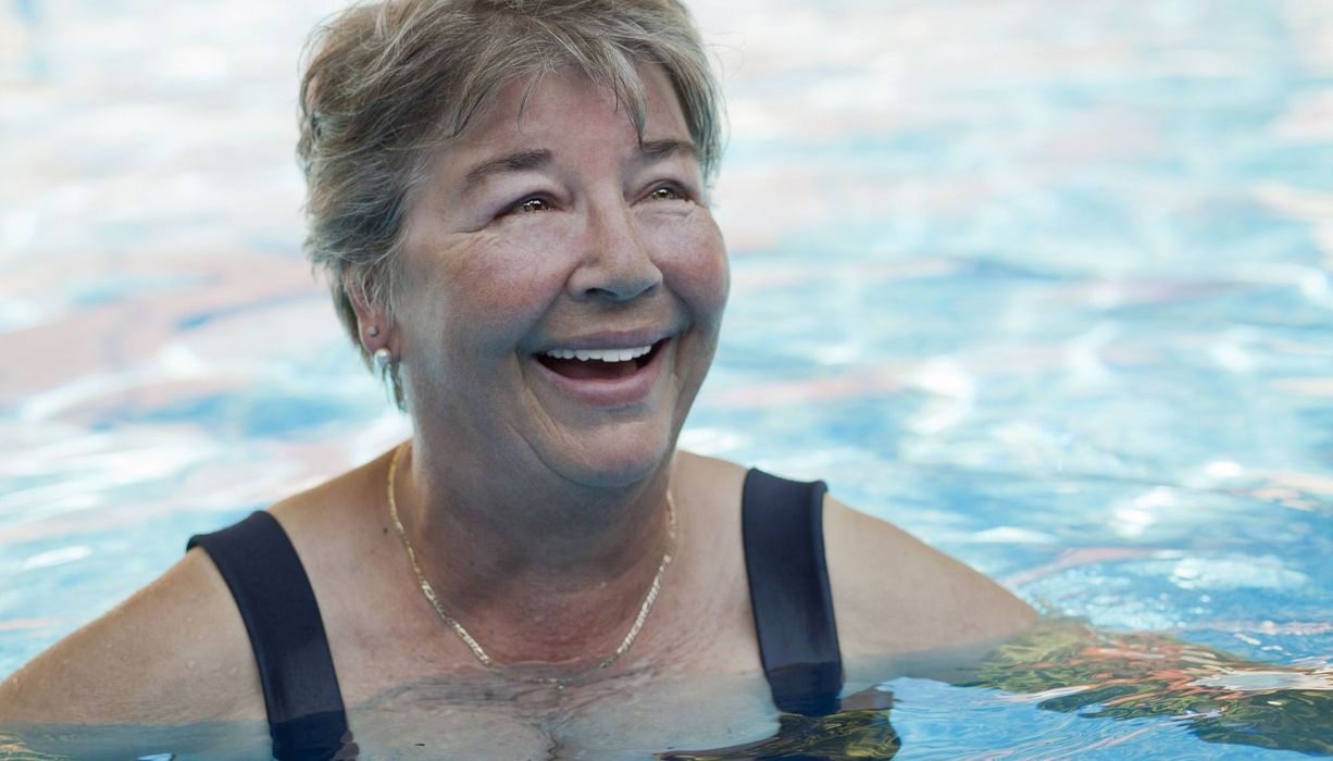 Ältere Frau, schwimmt im Wasser.