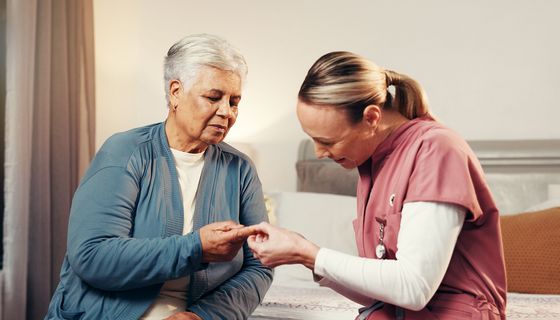 Pflegerin misst Frau den Blutzucker.