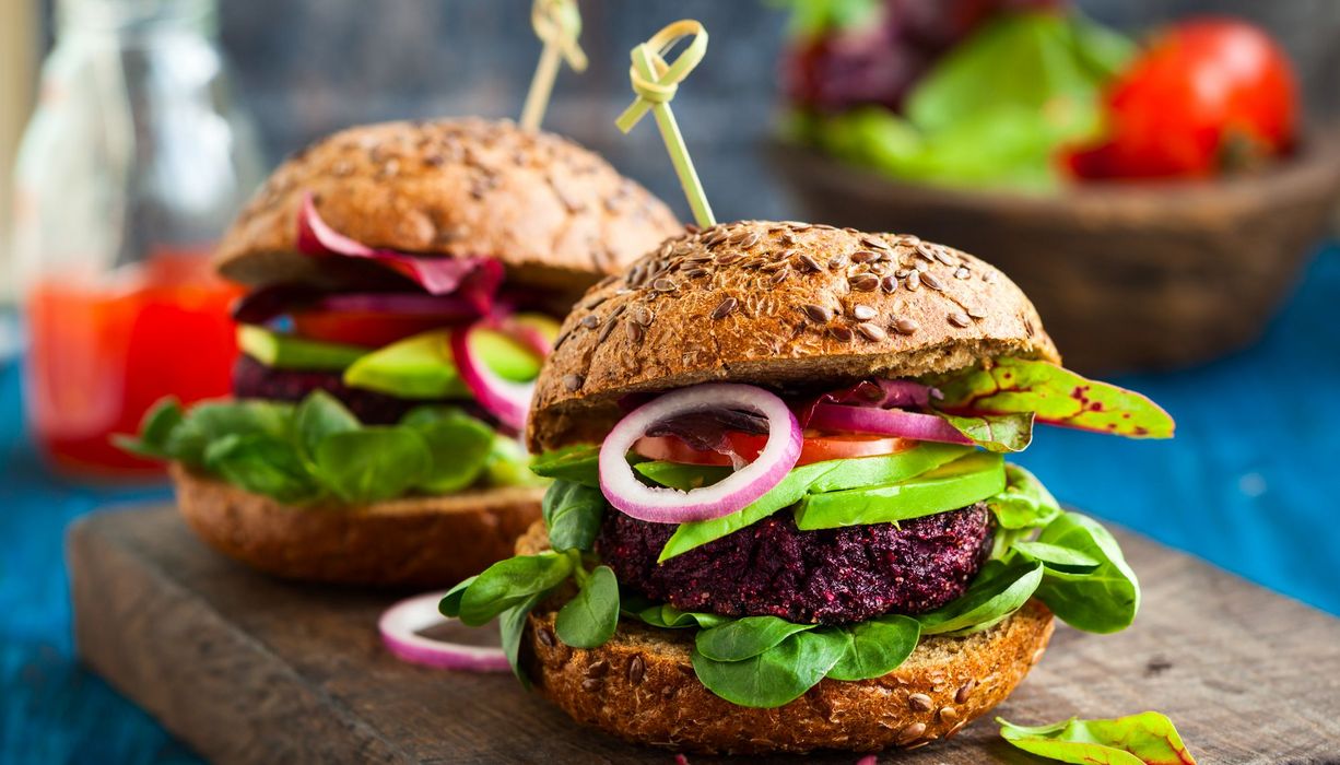 Zwei vegetarische Burger auf einem Holzbrett.