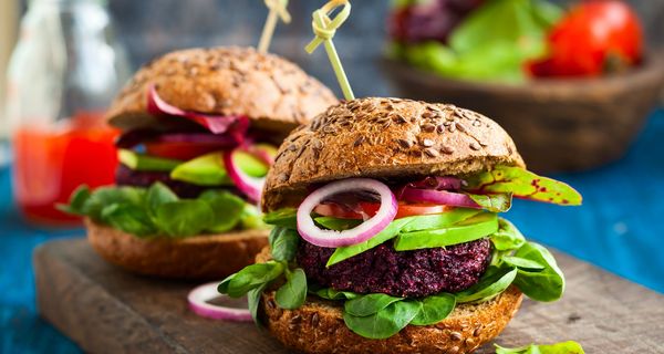 Zwei vegetarische Burger auf einem Holzbrett.