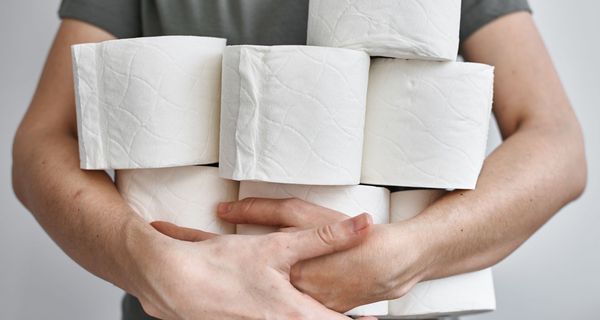 Mann trägt Klorollen auf dem Arm.