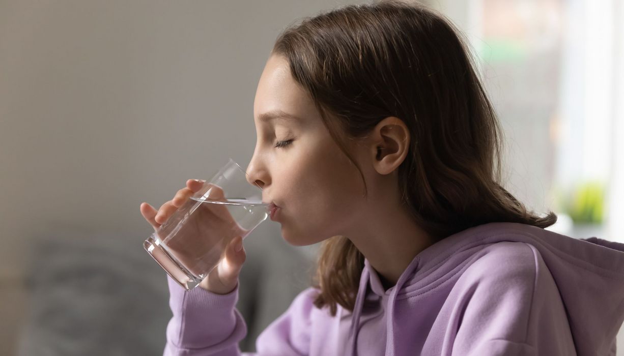 Mädchen, trinkt ein Glas Wasser.