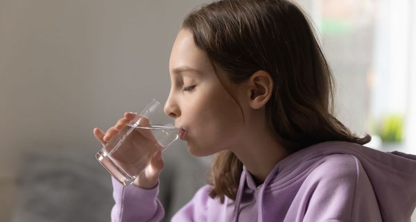 Mädchen, trinkt ein Glas Wasser.