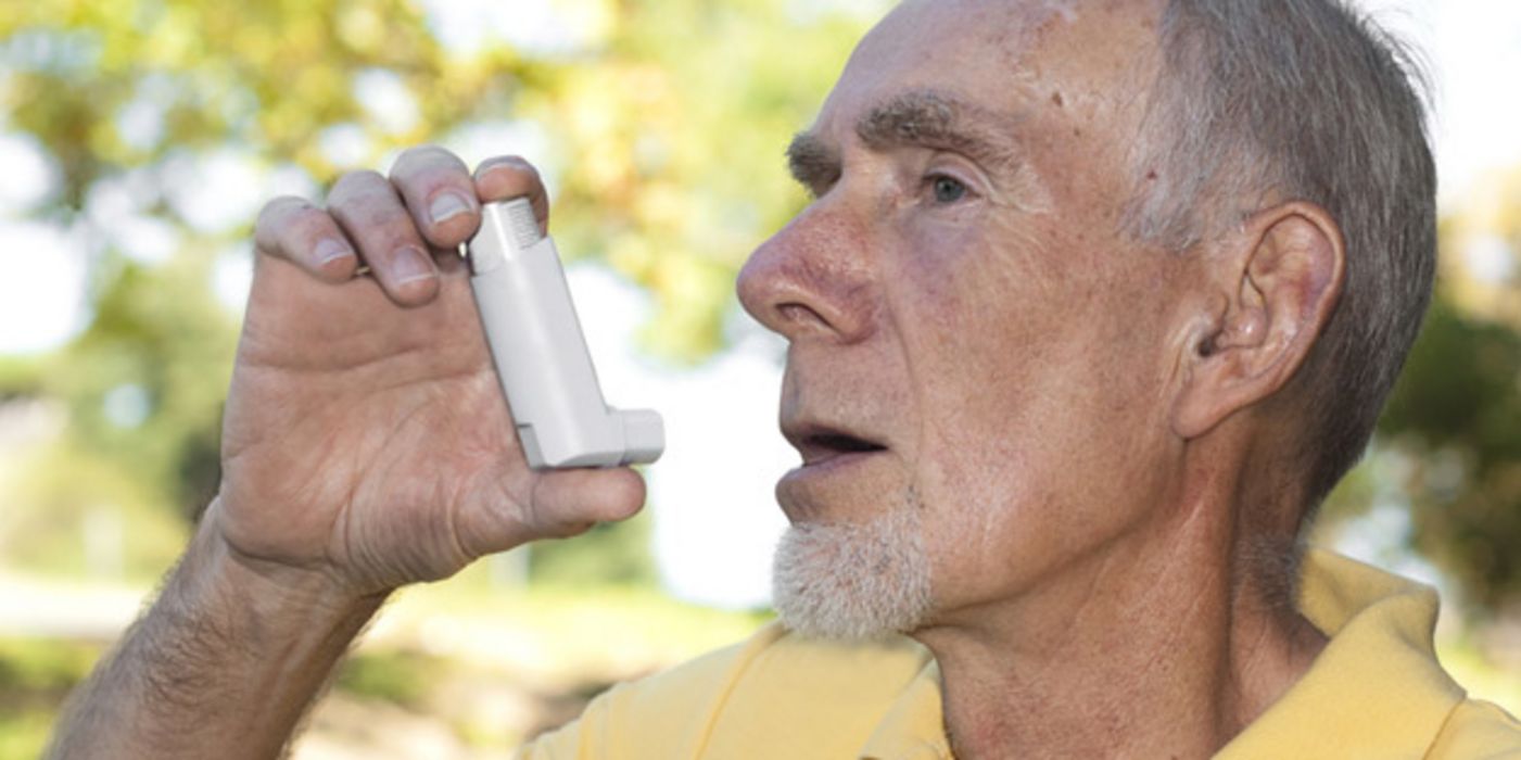 Älterer Mann nutzt Asthma-Spray.