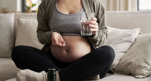 Schwangere Frau mit Nahrungsergänzungsmitteln.