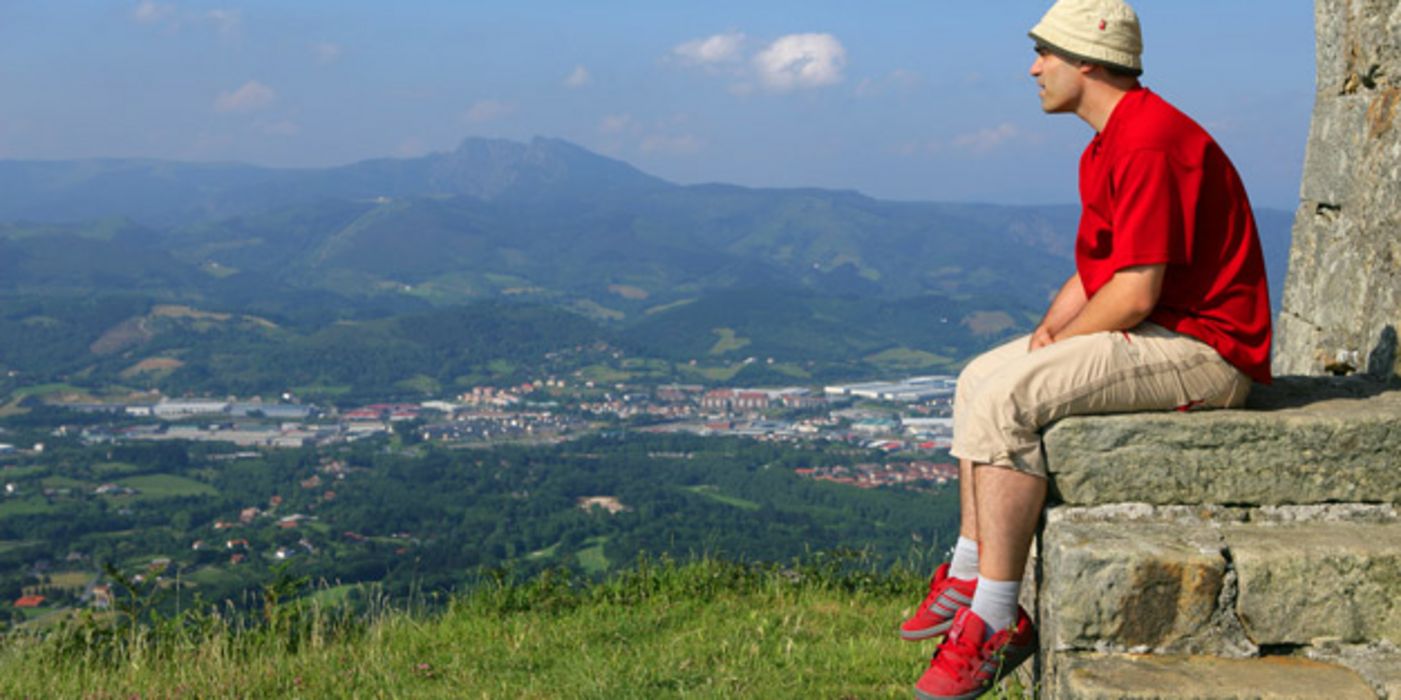 Mann mit Sonnenhut genießt einen Ausblick in der Natur.