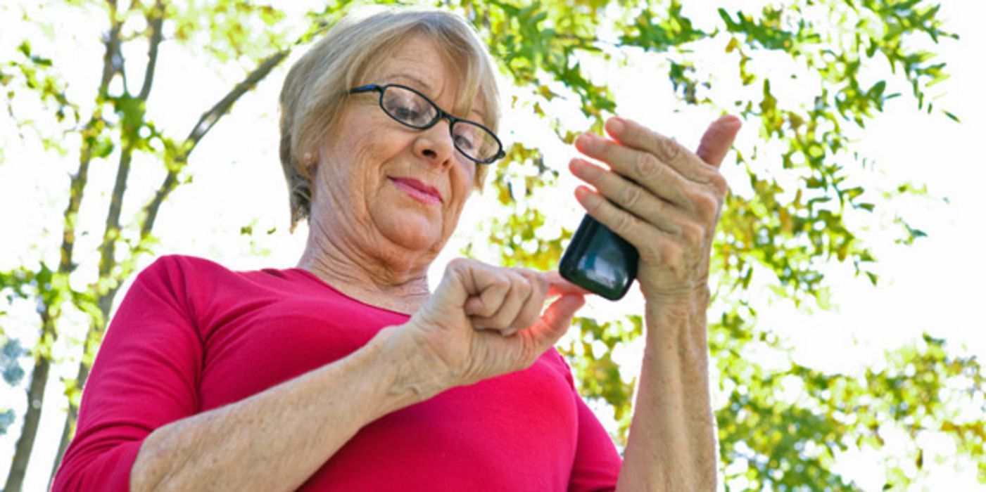 Seniorin mit Brille liest eine SMS