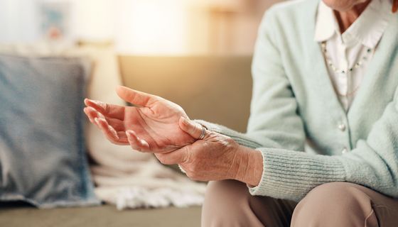 Frauenhände, die sich die Knöchel reiben.