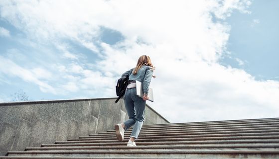 Junge Frau, läuft eine Treppe hoch.