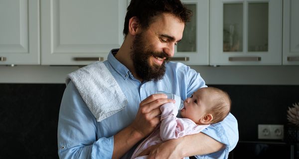 Vater, füttert sein Baby mit einer Flasche.