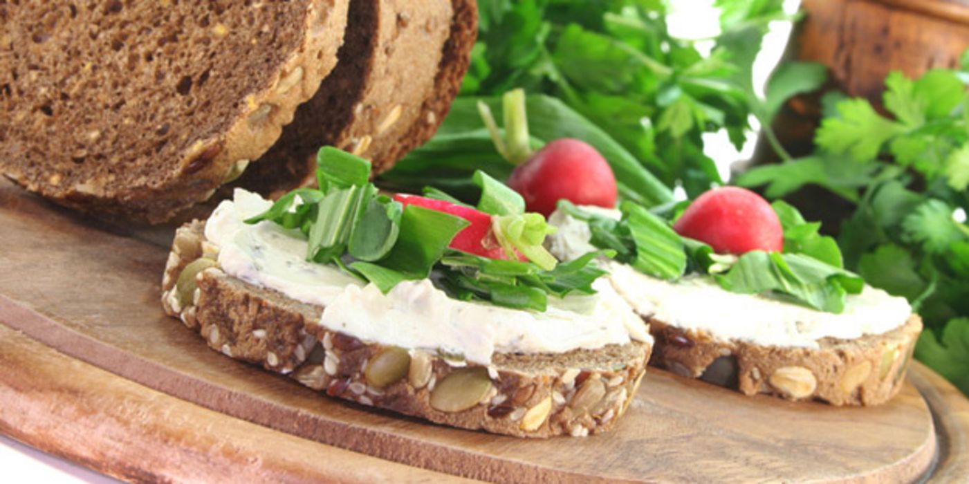 Zwei runde Scheiben Vollkornbrot mit Quark-Aufstrich