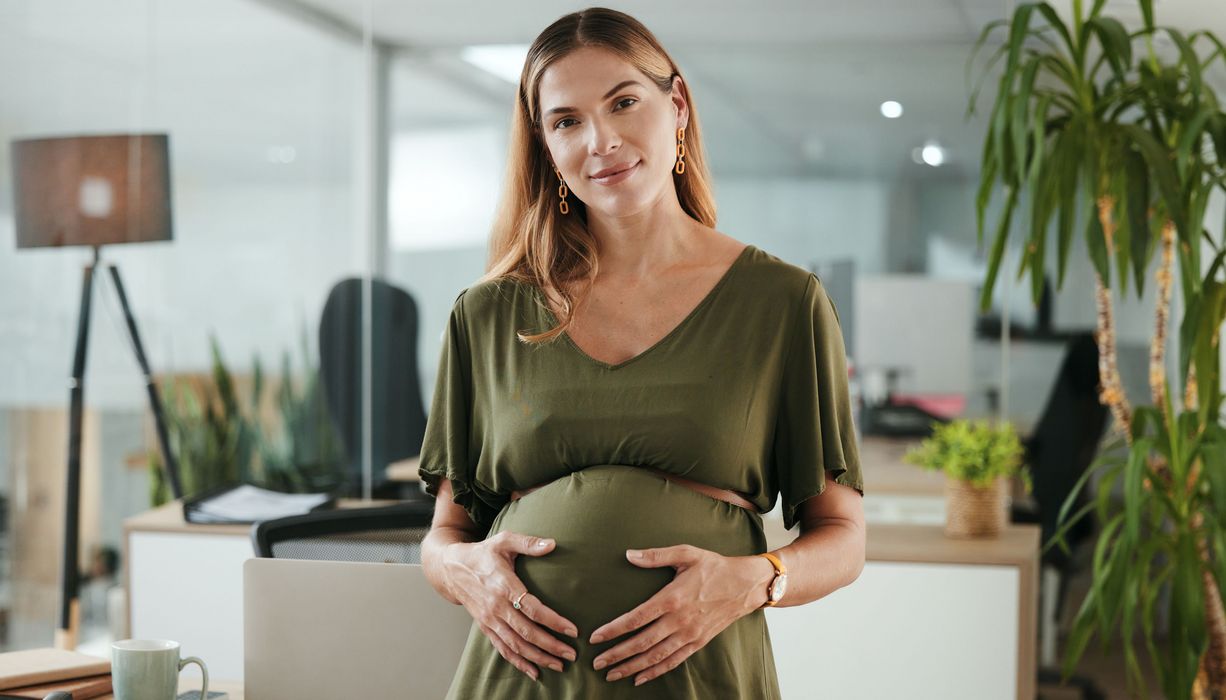 Schwangere Frau in grünem Kleid.