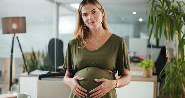 Schwangere Frau in grünem Kleid.