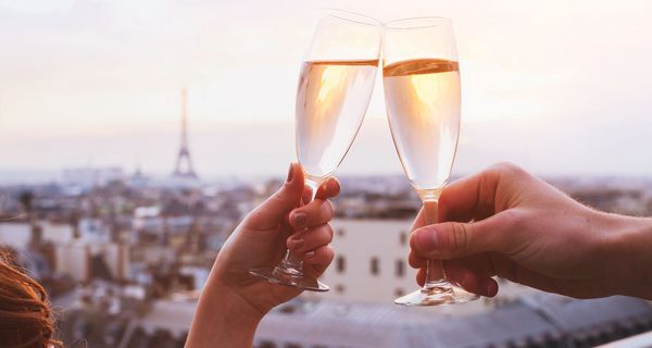 Zwei Personen, stoßen mit Sekt an.