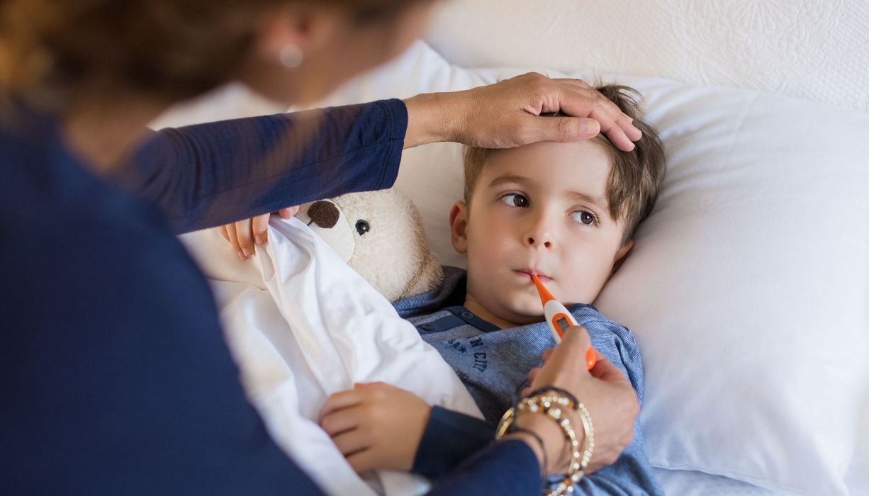 Mutter misst Fieber bei kleinem Jungen.