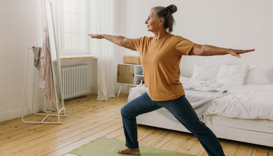 Ältere Frau, macht Gymnastik-Übungen zu Hause.