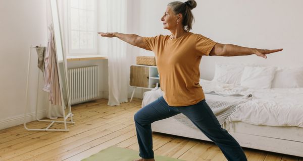 Ältere Frau, macht Gymnastik-Übungen zu Hause.