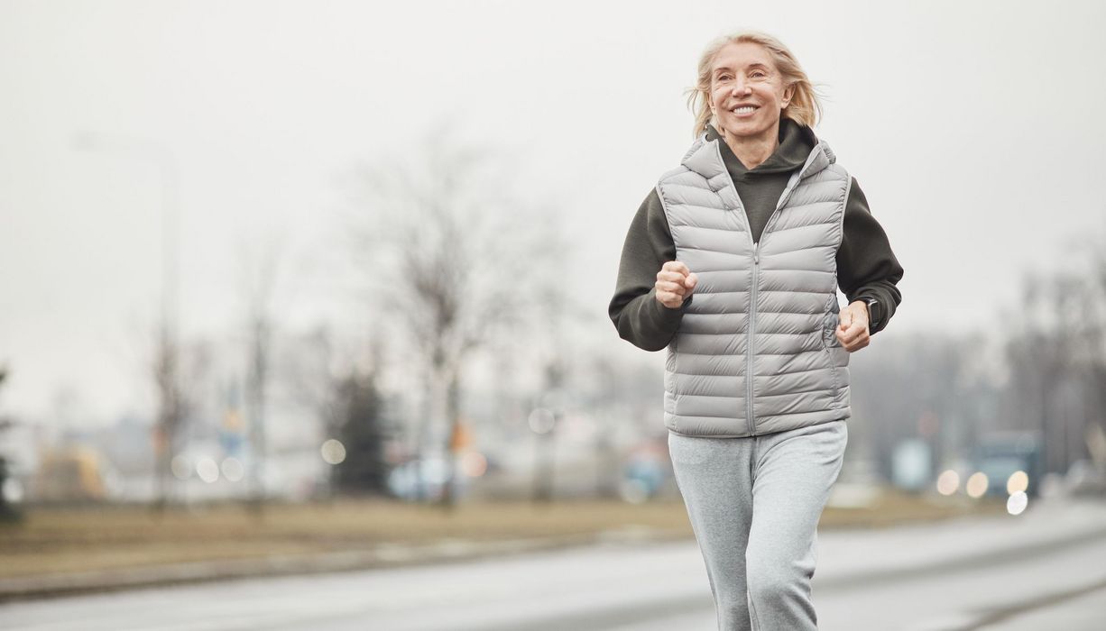 Ältere Frau, joggt an einem winterlichen Tag.