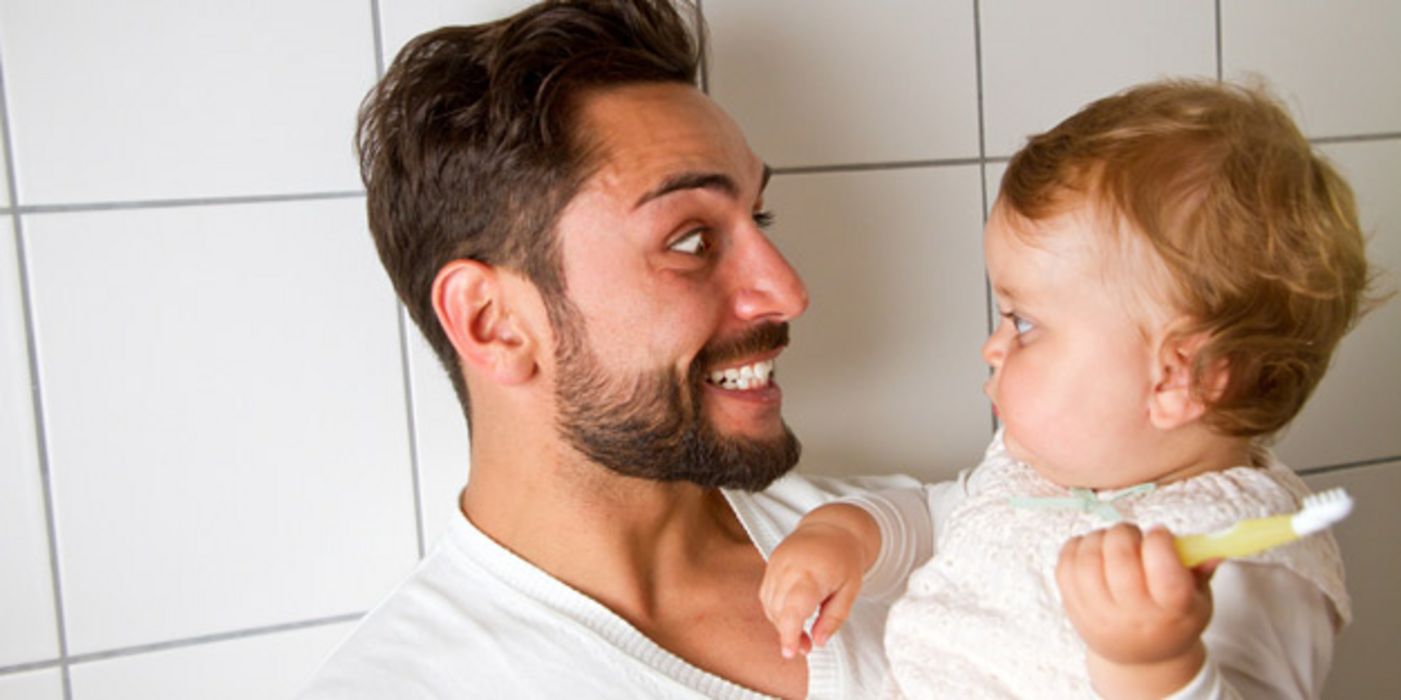 Vater mit Baby beim Zähneputzen