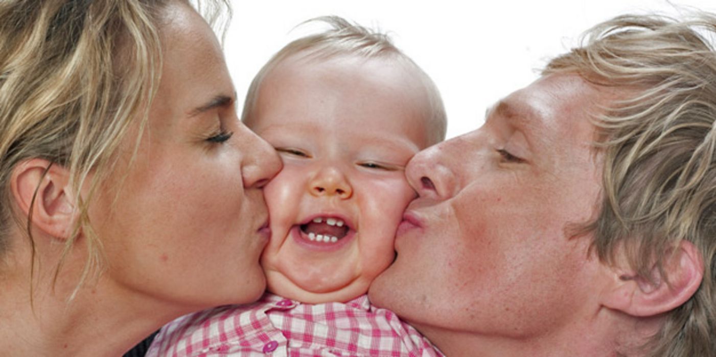 Mutter und Vater küssen ihr Baby.