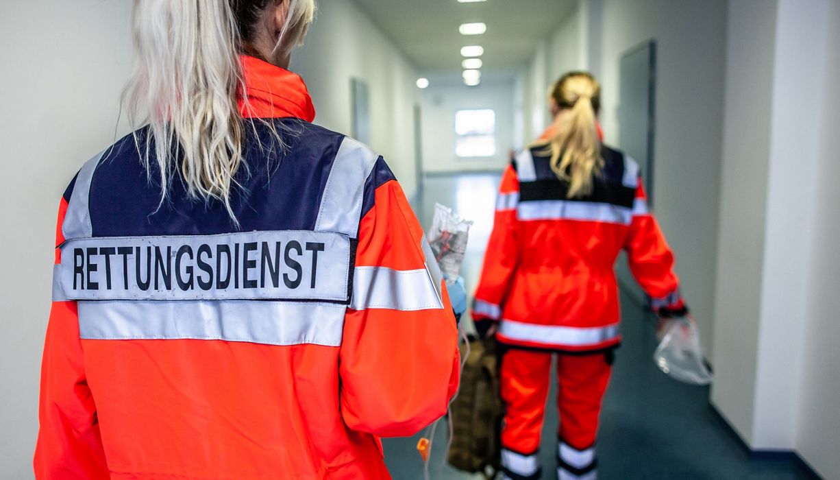 Zwei Frauen vom Rettungsdienst, laufen durch einen Flur.