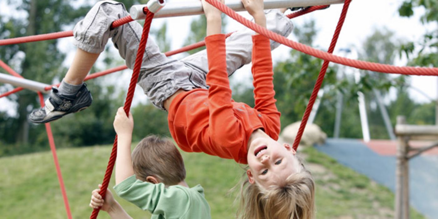 Kinder turnen auf einem Klettergerüst.