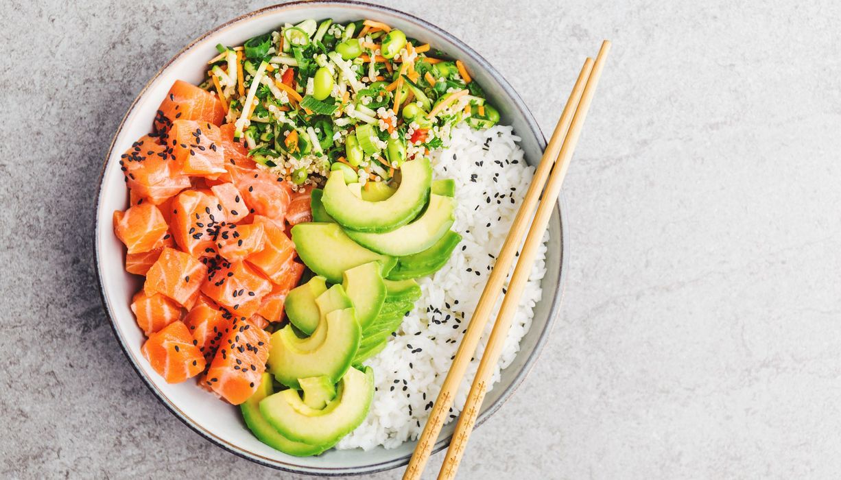 Foto von Bowl mit Lachs, Avocado, Gemüse und Reis.