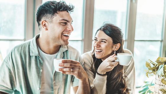 Fröhliches Paar trinkt zusammen Kaffee.
