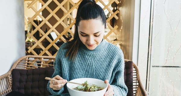 Junge Frau, isst eine Suppe.