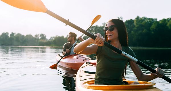 Junges Paar beim Paddeln auf einem Fluss.