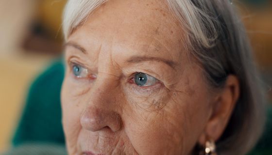 Nahaufnahme von der oberen Gesichtshälfte einer älteren Dame. Der Fokus liegt auf den Augen.