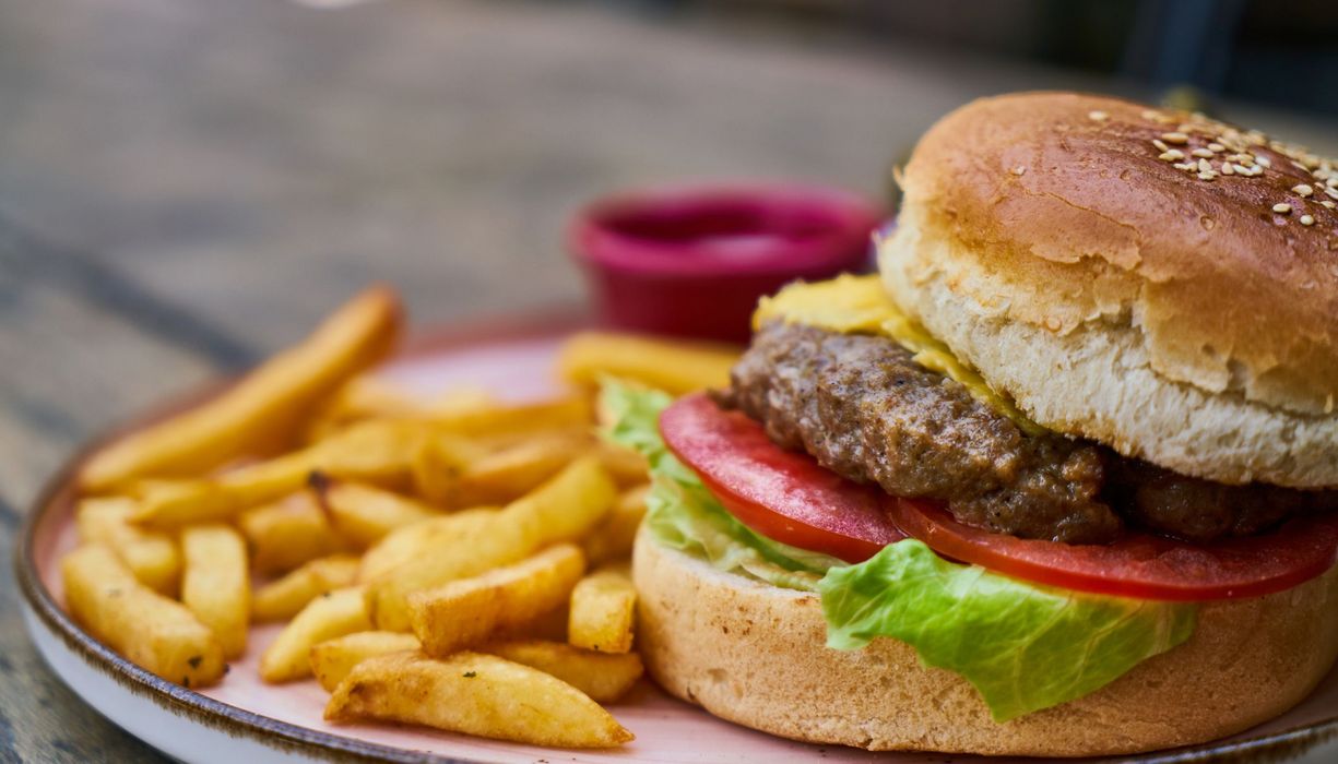 Burger und Pommes auf einem Tisch.