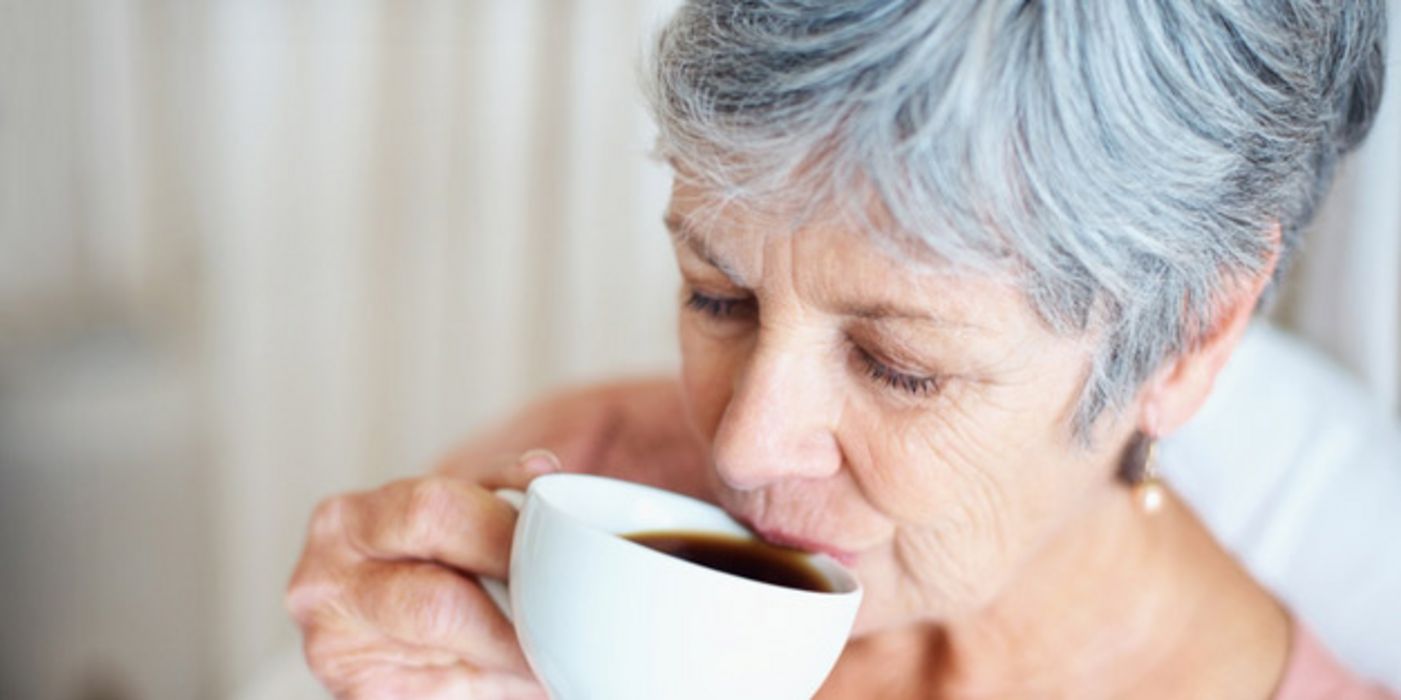 Ältere Frau trinkt Kaffee