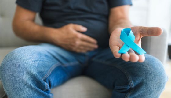 Mann, hält eine blaue Schleife als Symbol für Prostatakrebs in der Hand.