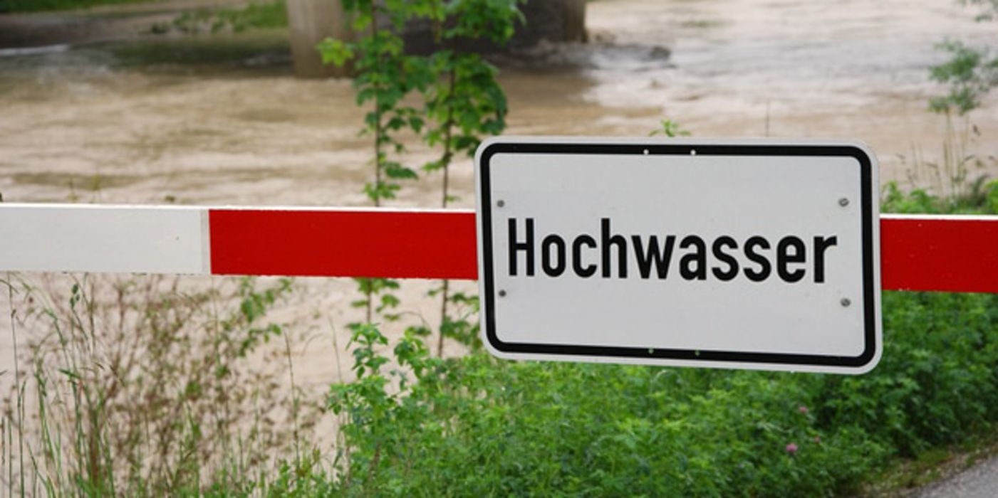 Hochwasser führender Fluss mit Hochwasser-Warnschild