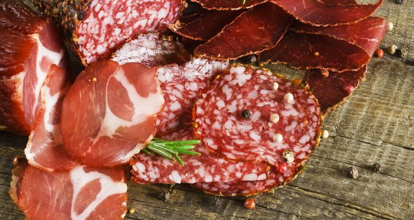 Verschiedene Wurstaufschnitte auf einer Holzplatte.