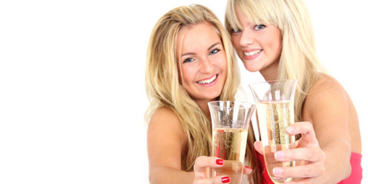 Zwei blonde Frauen in den 20ern im Partylook prosten Kamera mit Sekt zu