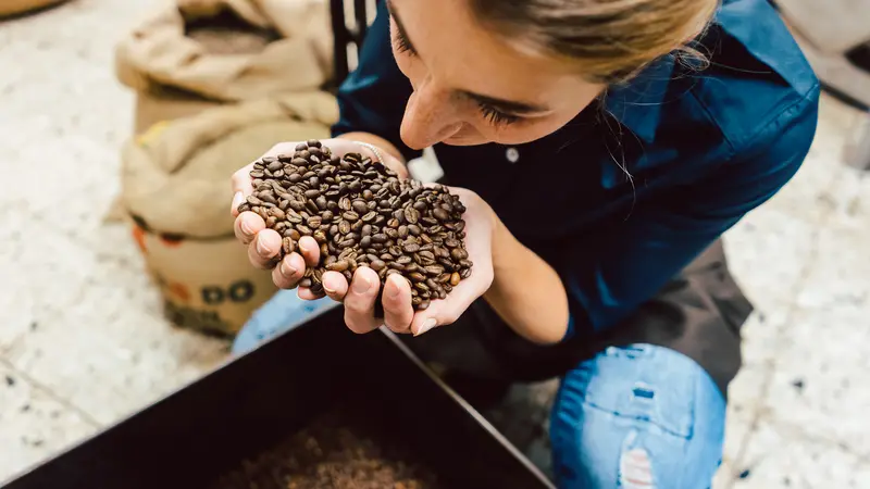 Frau hält Kaffeebohnen in der Hand