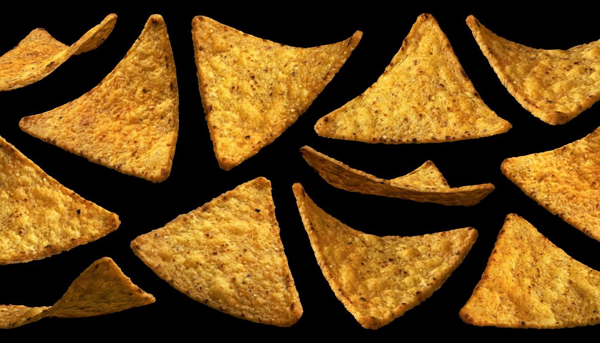 Tortilla Chips auf schwarzem Hintergrund.