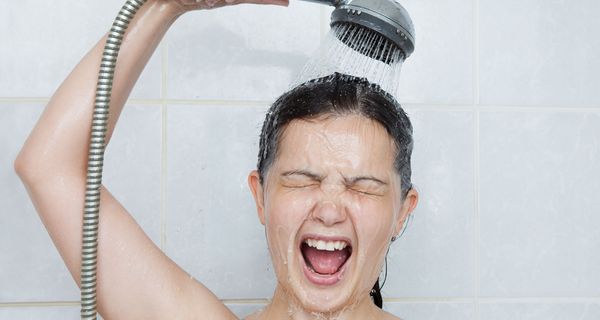 Junge Frau duscht kalt.