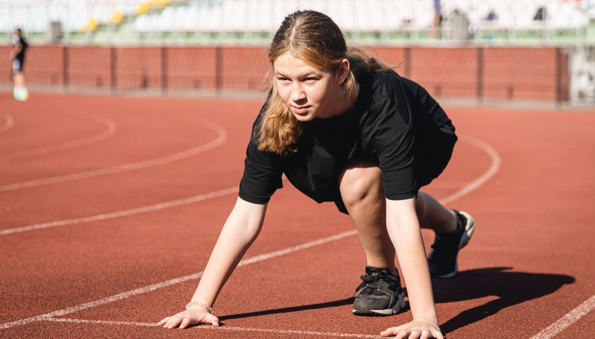 Junges Mädchen auf dem Sportplatz.